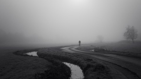 Man cycling in fog